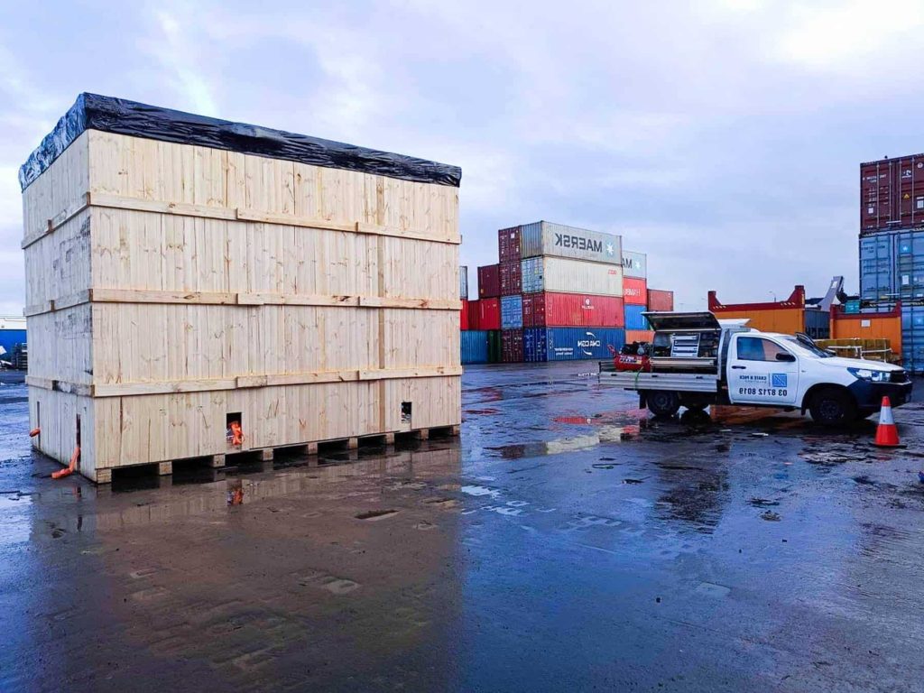 large wooden shipping crate and crate n pack solutions branded ute with shipping containers in the background